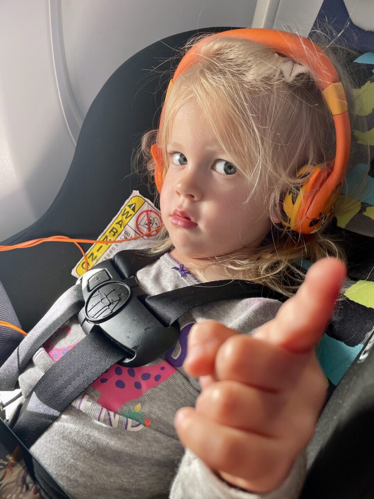 toddler with headphones on plane