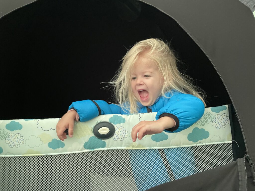 Toddler in pack n play and slumber pod in camping tent