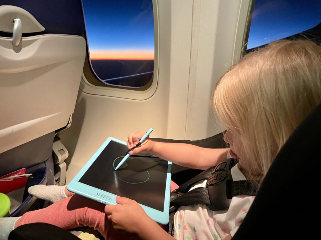 Toddler using drawing board on plane